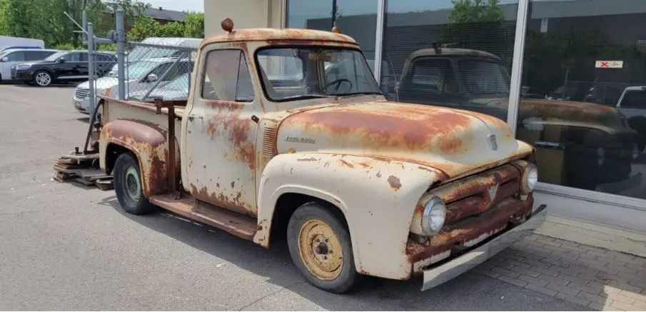 as he explored the outskirts of town, Joe stumbled upon a rusted and abandoned 1953 Ford pickup truck hidden in an overgrown field.