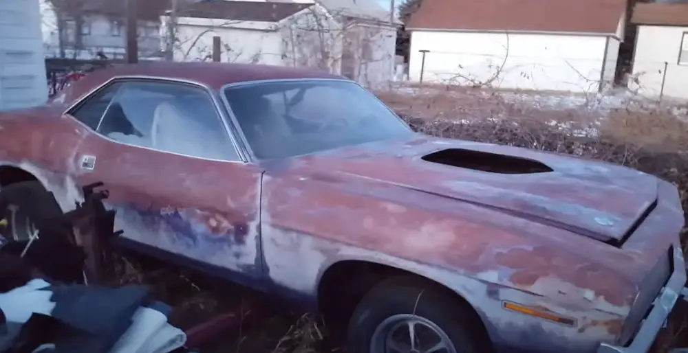 A 1970 Plymouth Cuda with a rust-covered exterior