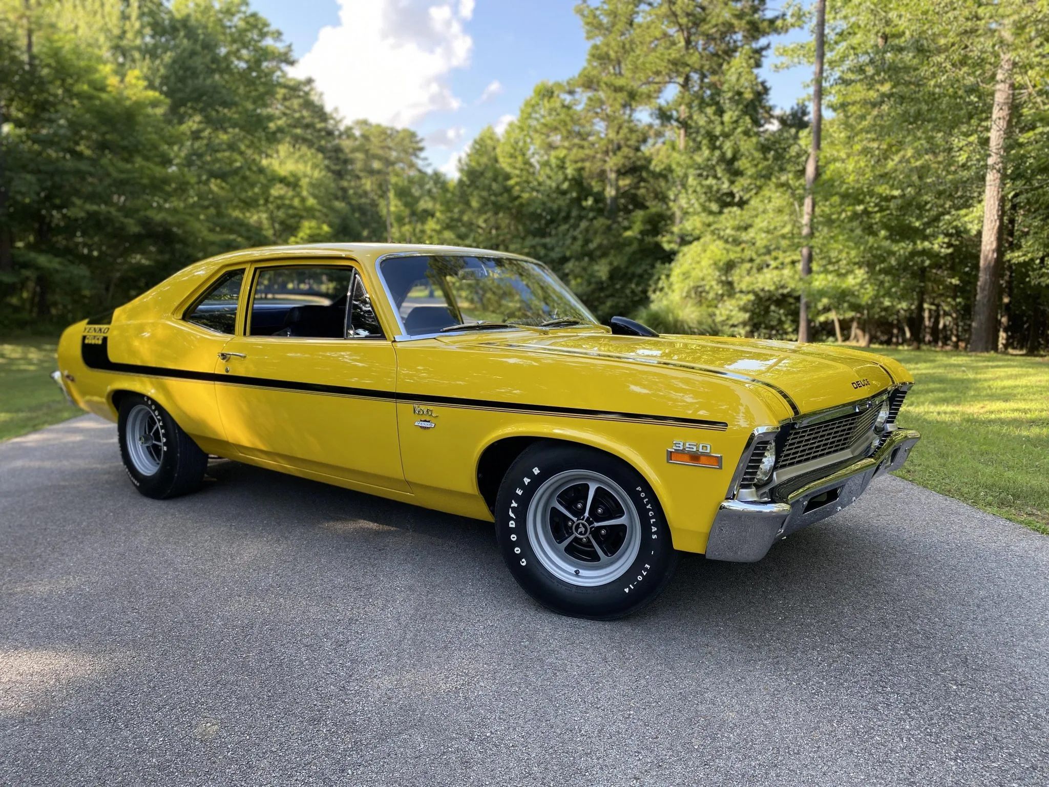 Front 3/4 shot of a parked yellow 1970 Nova with forest background