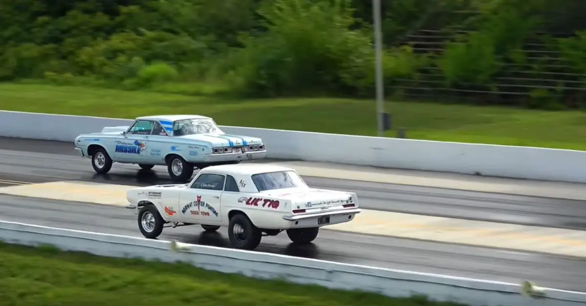 Rear quarter view - 60's Nostalgia Super Stock drag racers on track