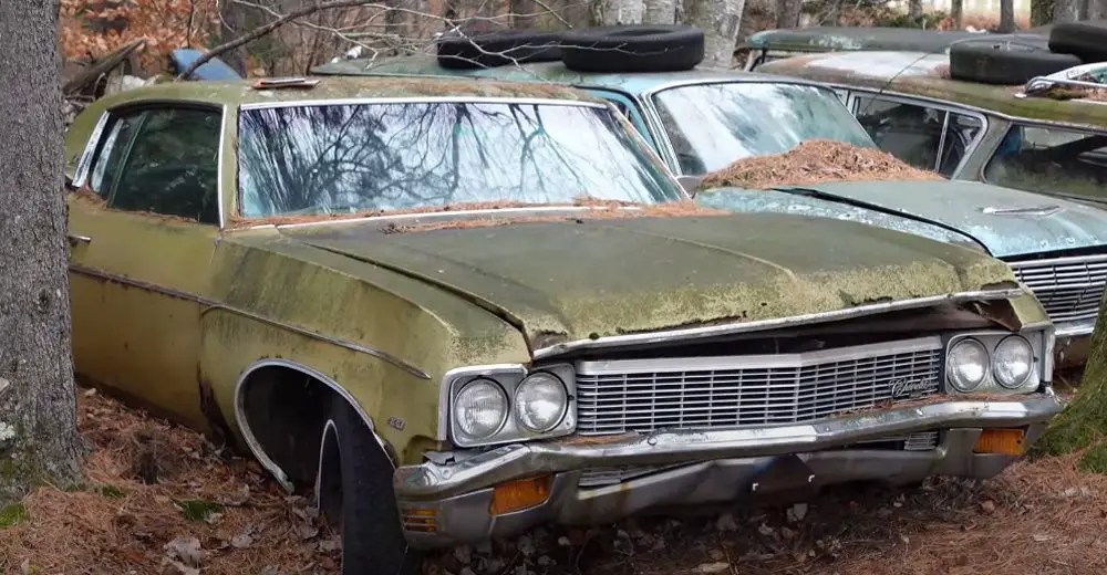 A 1970 Chevrolet Impala sitting in a junkyard