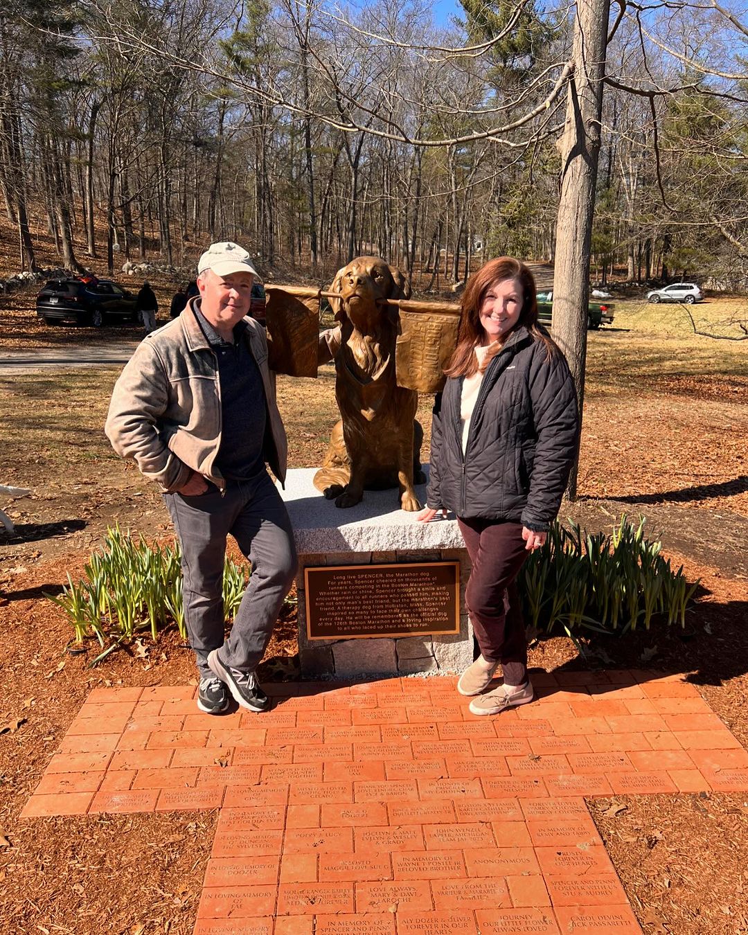 man and woman next to a dog statue