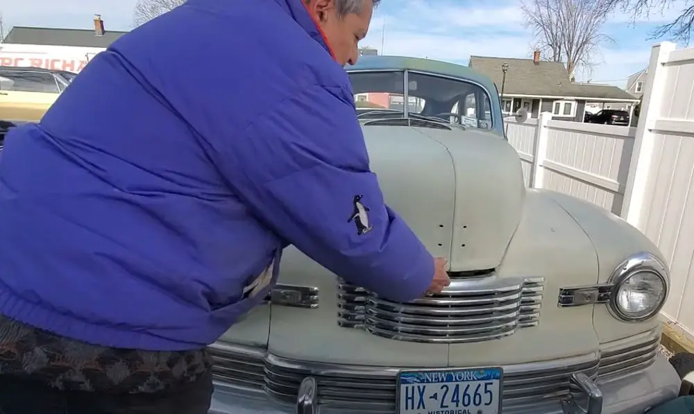 Owner Emilio lifts the hood of his 1948 Nash Ambassador