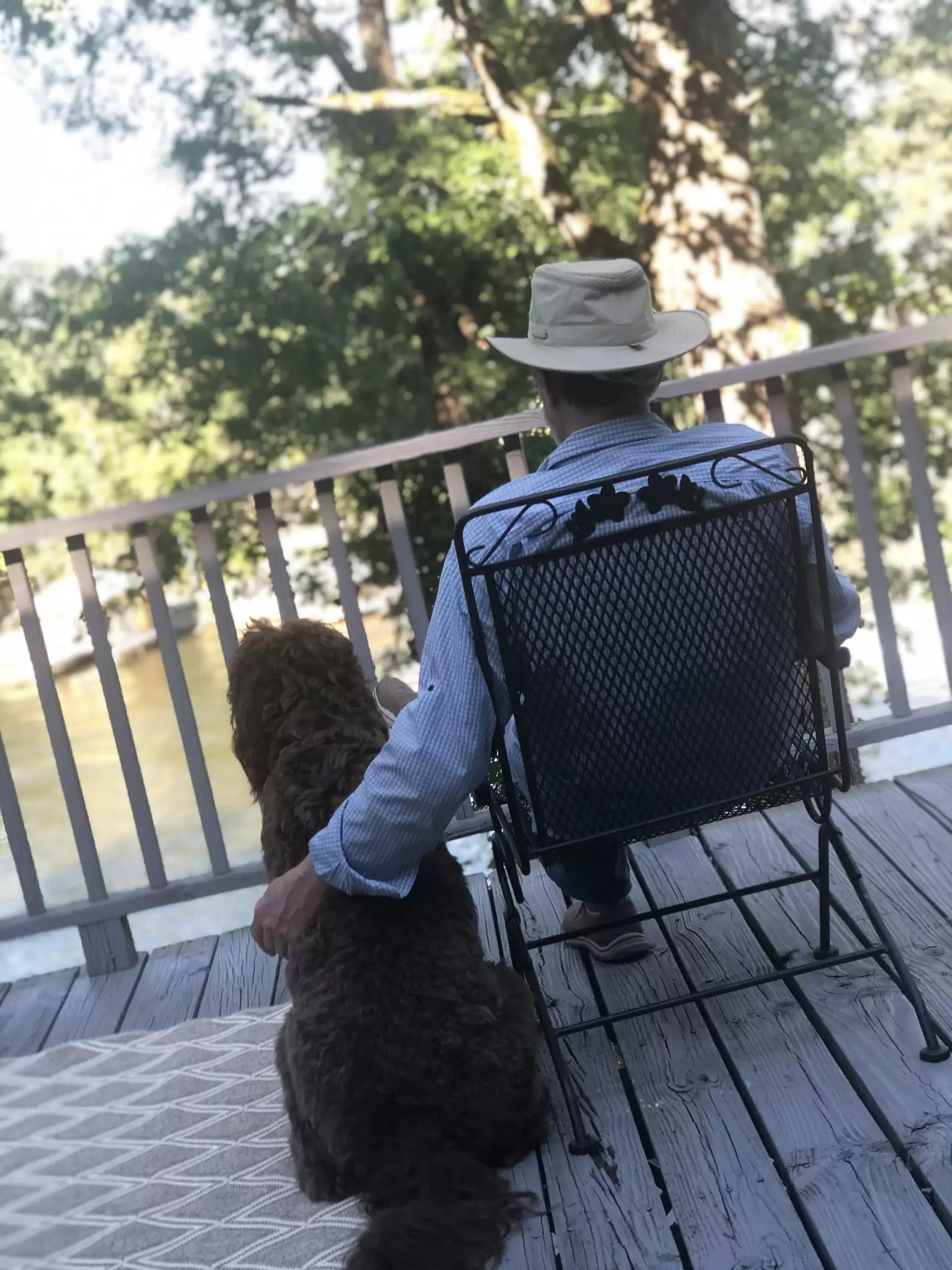 photo of man sitting and hugging the dog