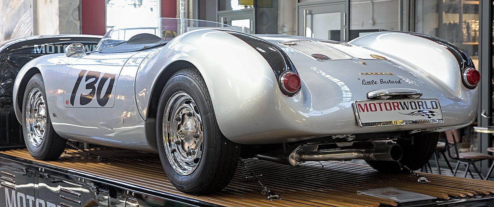 A silder Porsche 550 Spyder with 130 painted on it. 