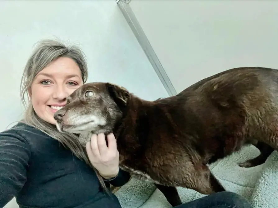 smiling woman hugging with dog