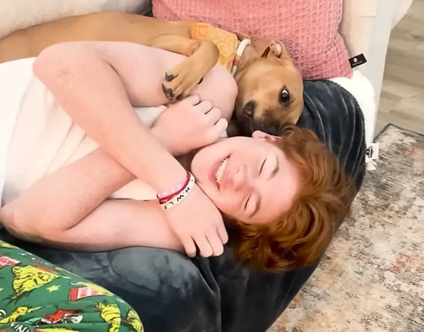 woman and dog cuddling on couch