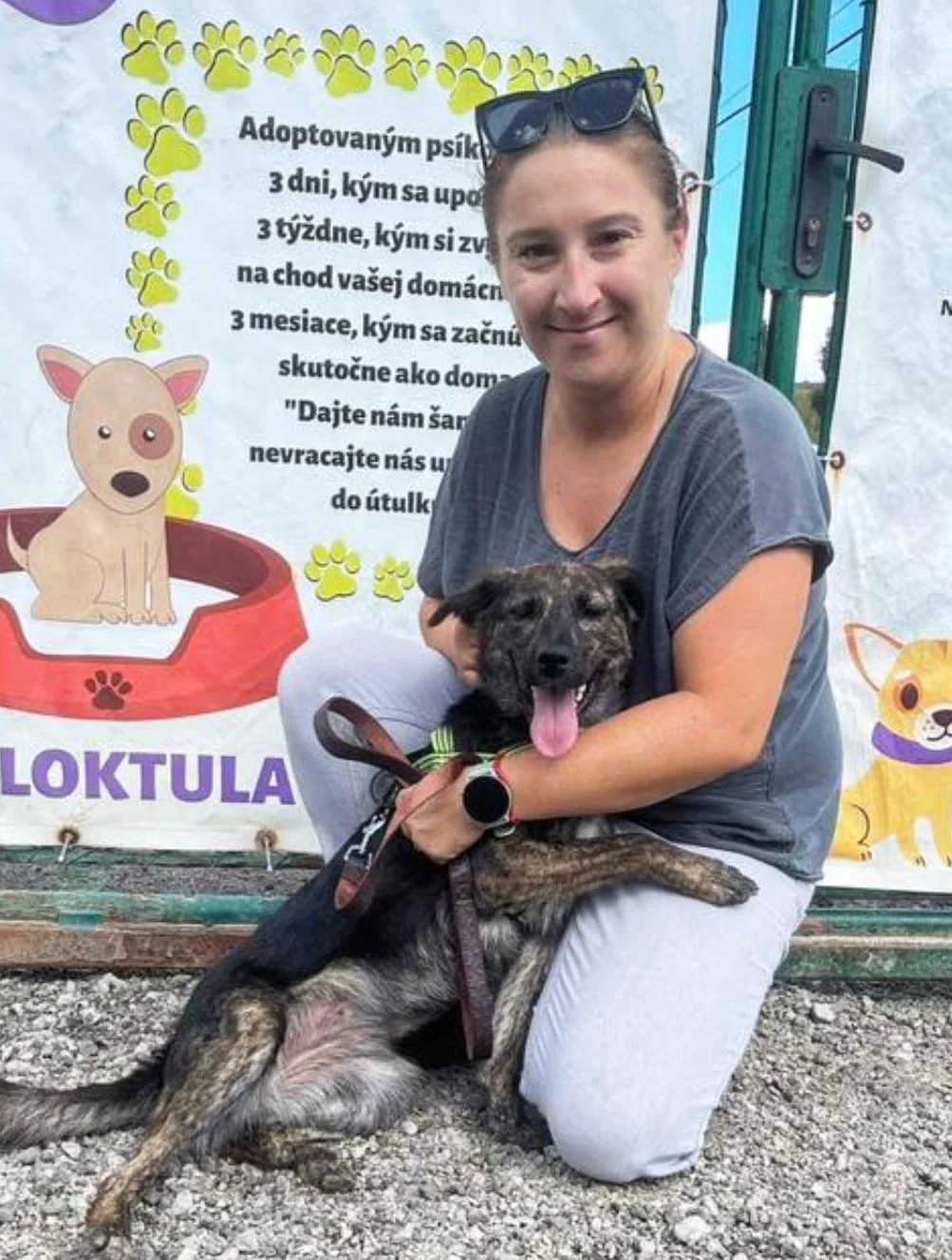 woman hugging black dog